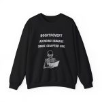 Cozy Booktrovert crewneck sweatshirt featuring a skeleton reading a book and the quote “Booktrovert – Avoiding Humans Since Chapter One” in black and white design.