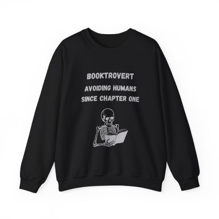 Cozy Booktrovert crewneck sweatshirt featuring a skeleton reading a book and the quote “Booktrovert – Avoiding Humans Since Chapter One” in black and white design.