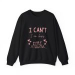 Pink fleece sweatshirt with girl reading and quote “I can’t, I am busy” – cozy clothing for book lovers.
