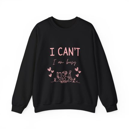 Pink fleece sweatshirt with girl reading and quote “I can’t, I am busy” – cozy clothing for book lovers.